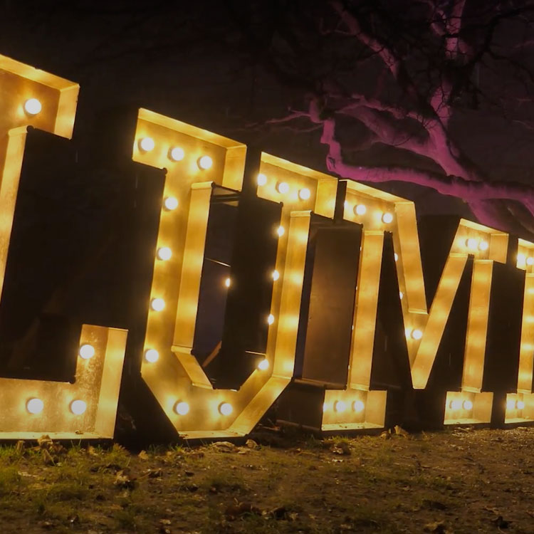 Giant light-up letters glowing on the grass