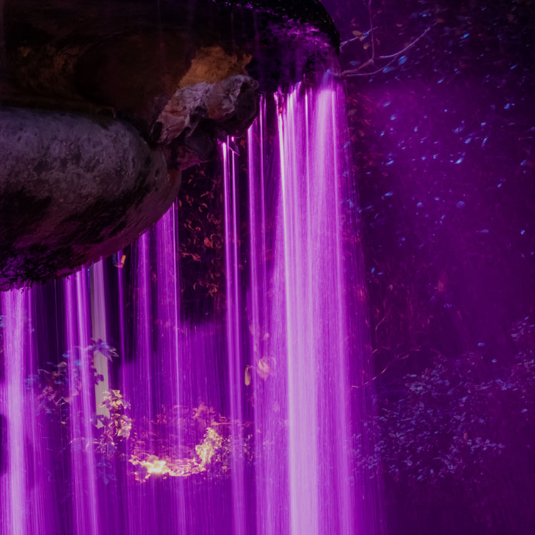A curtain of purple light falling like a waterfall over the rocks