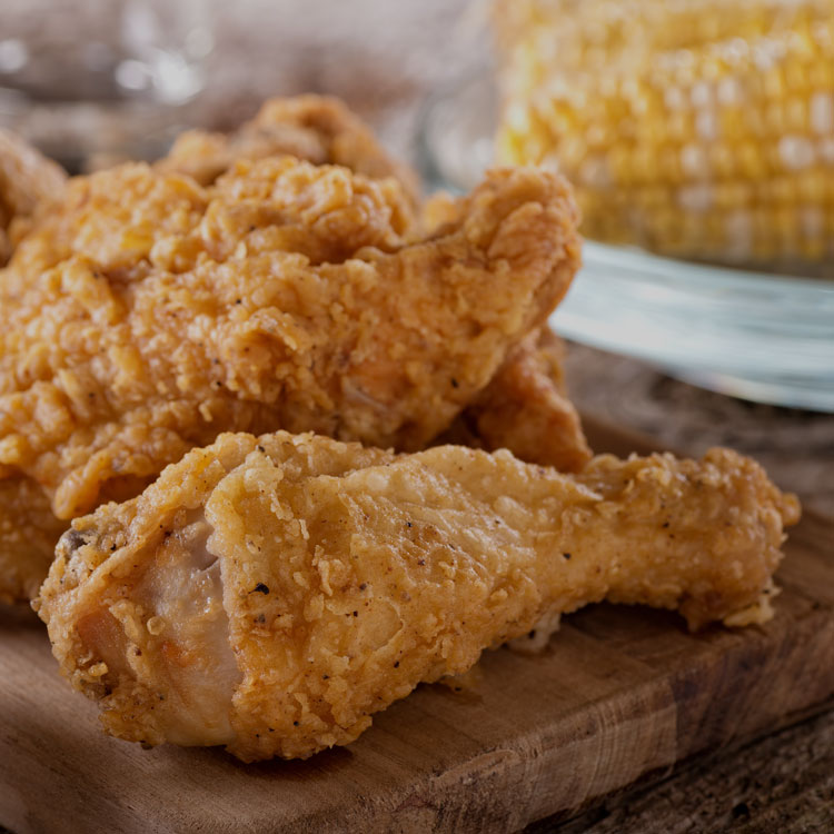 Golden fried chicken pieces on a wooden board